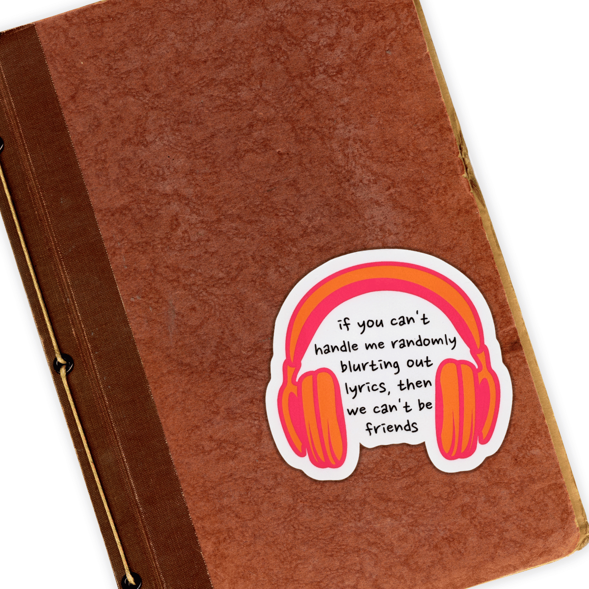 Brown notebook with a sticker featuring headphones and text on a white background