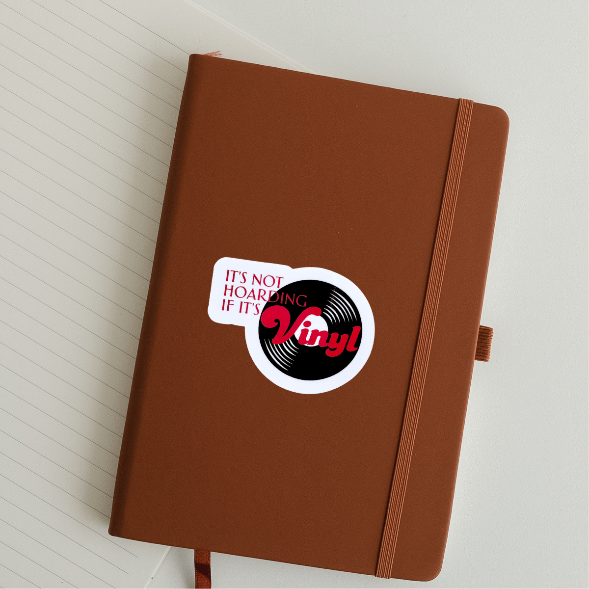 Brown notebook with a vinyl record sticker on a white background