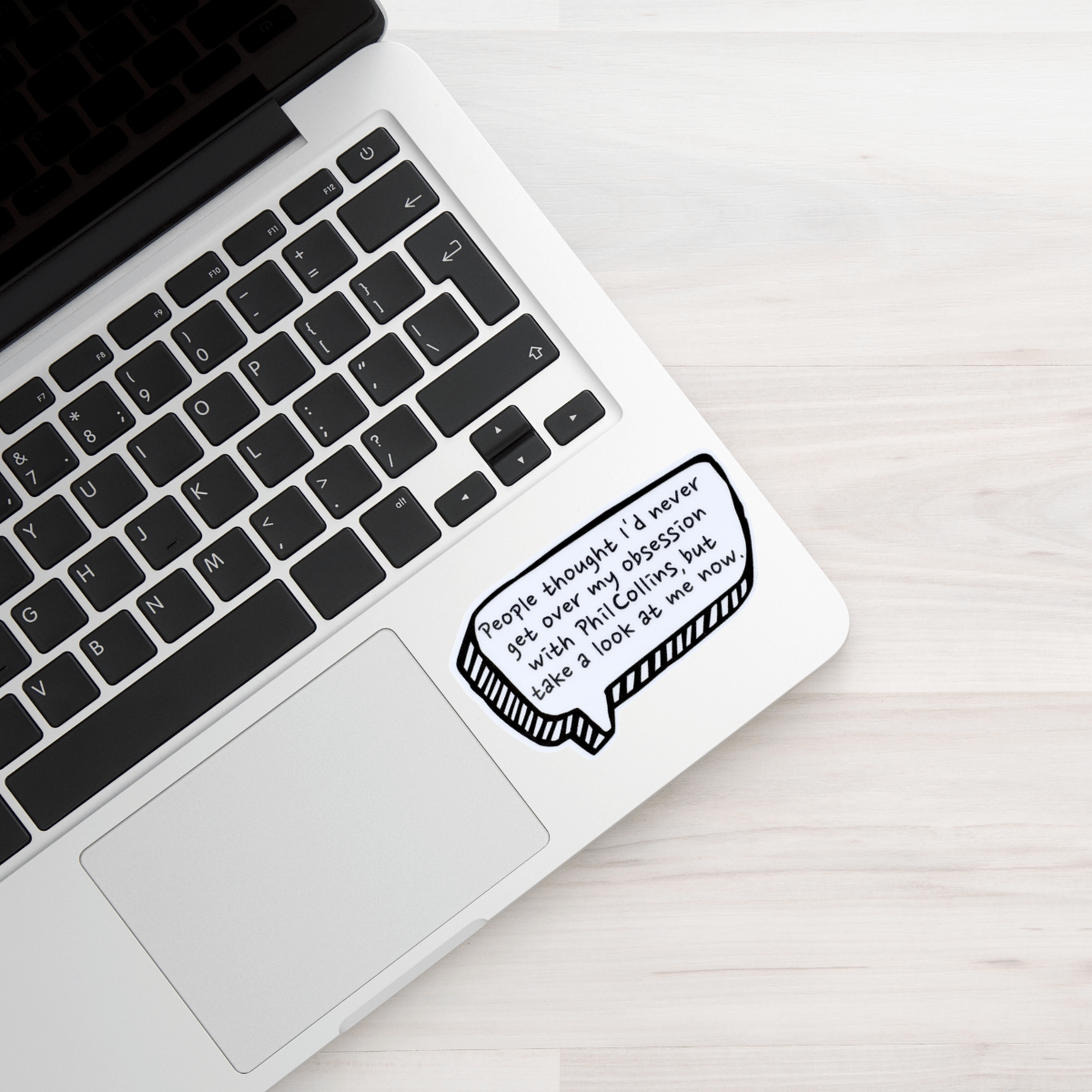 Laptop with a sticker on the palm rest area featuring text.