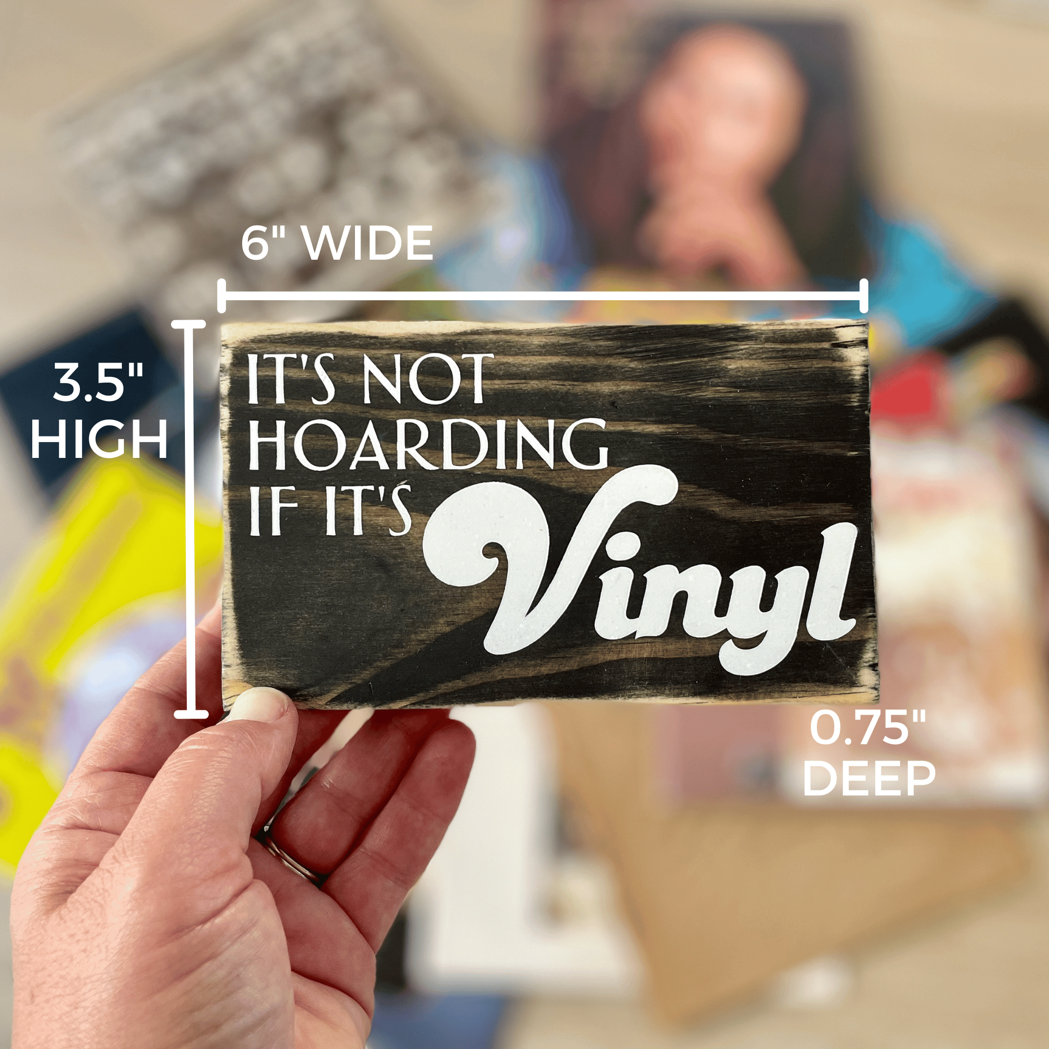 Shows the dimensions of the sign that reads "It's not hoarding if it's vinyl" which are 6" wide, 3.5" high and 0.75" deep.