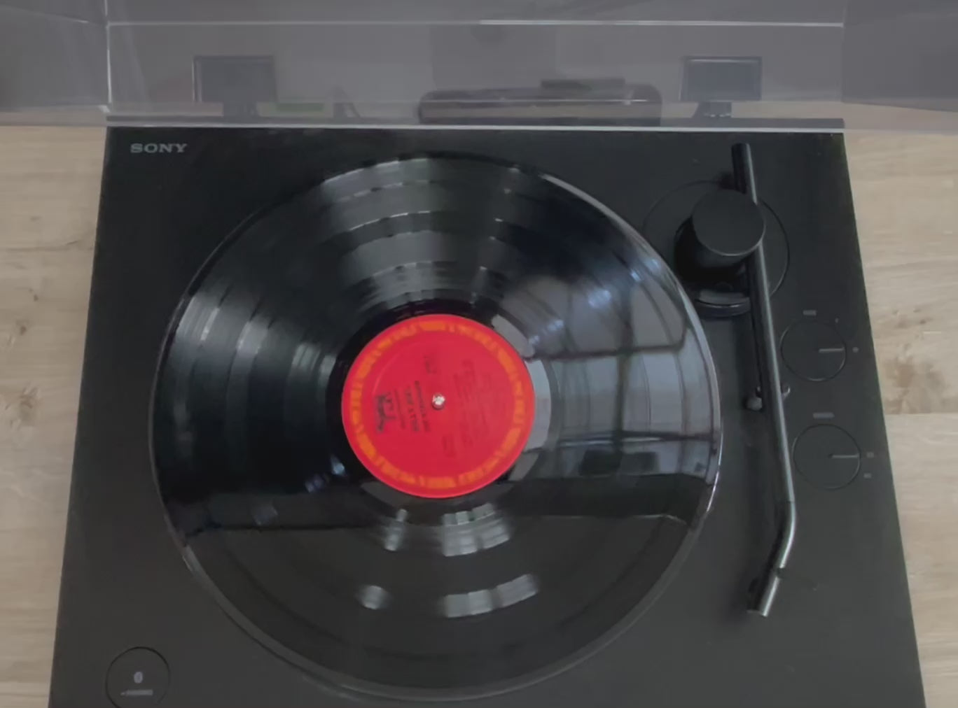 a video of a record player spinning. the cover is put down and the black wood sign is placed on top.