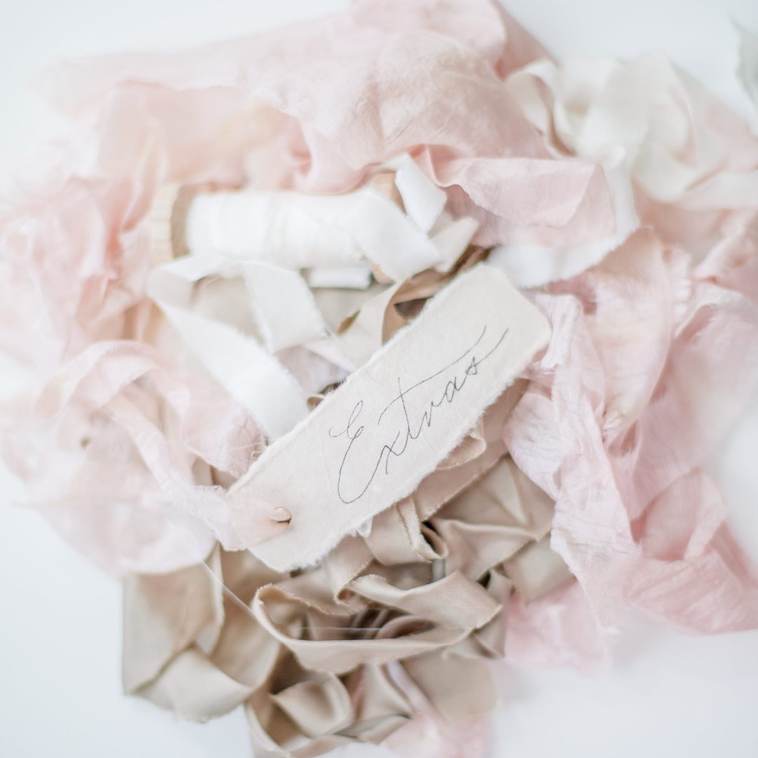 a pile of pink and white scrap fabric labeled "extras"