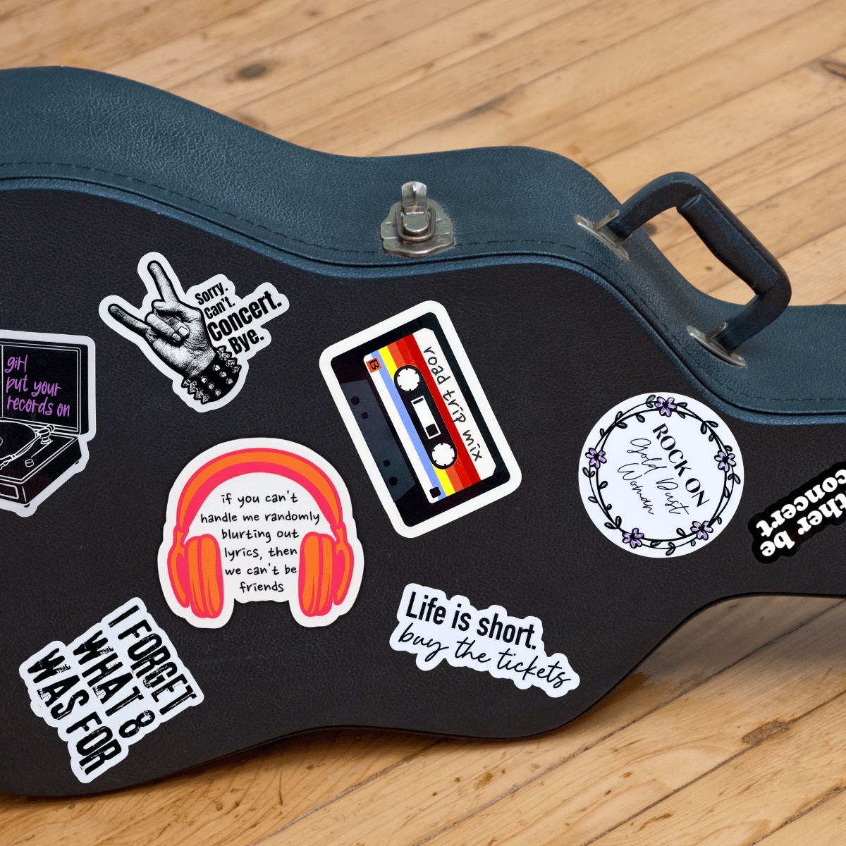 Guitar case with various stickers on a wooden floor