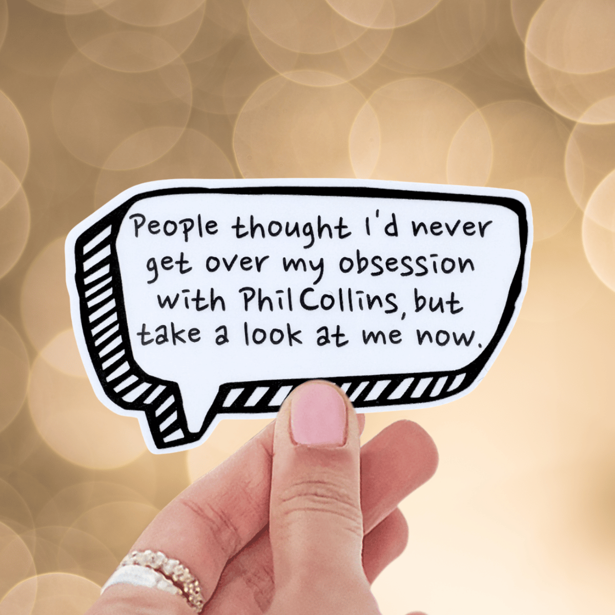 Hand holding a speech bubble with text on a blurred background