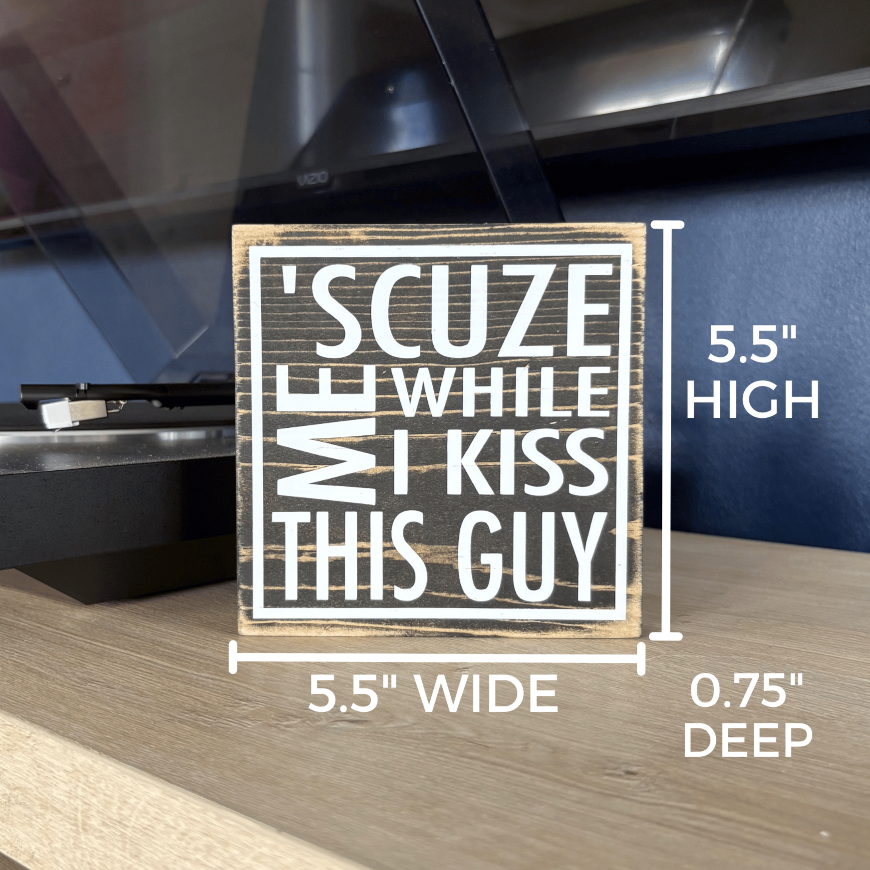 Wooden sign with humorous text on a shelf in front of a record player. The sign's measurements are noted: 5.5" x 5.5" x 0.75"