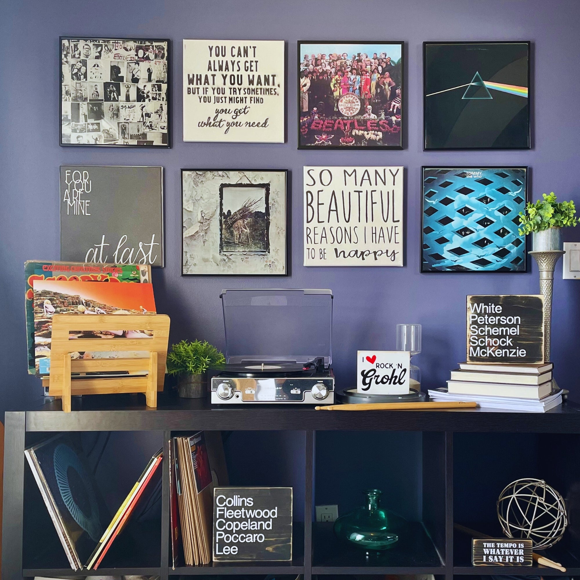 View of a room with album covers on the wall, records on a table and a variety of Three Sisters Studio drum signs on shelves. 