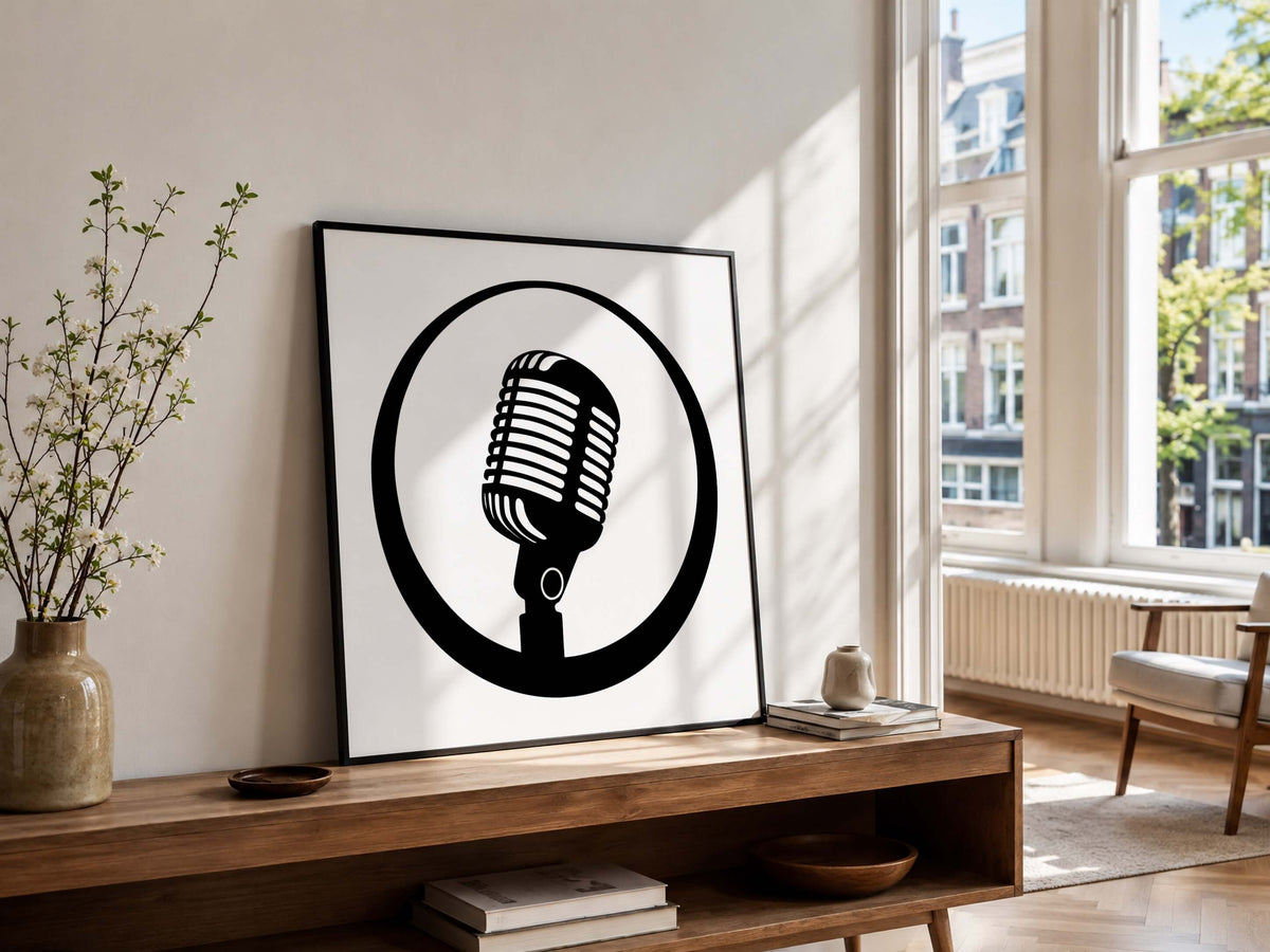 A framed black and white art print featuring a retro microphone inside a circle, leaning on a wooden console table in a bright, modern living room.