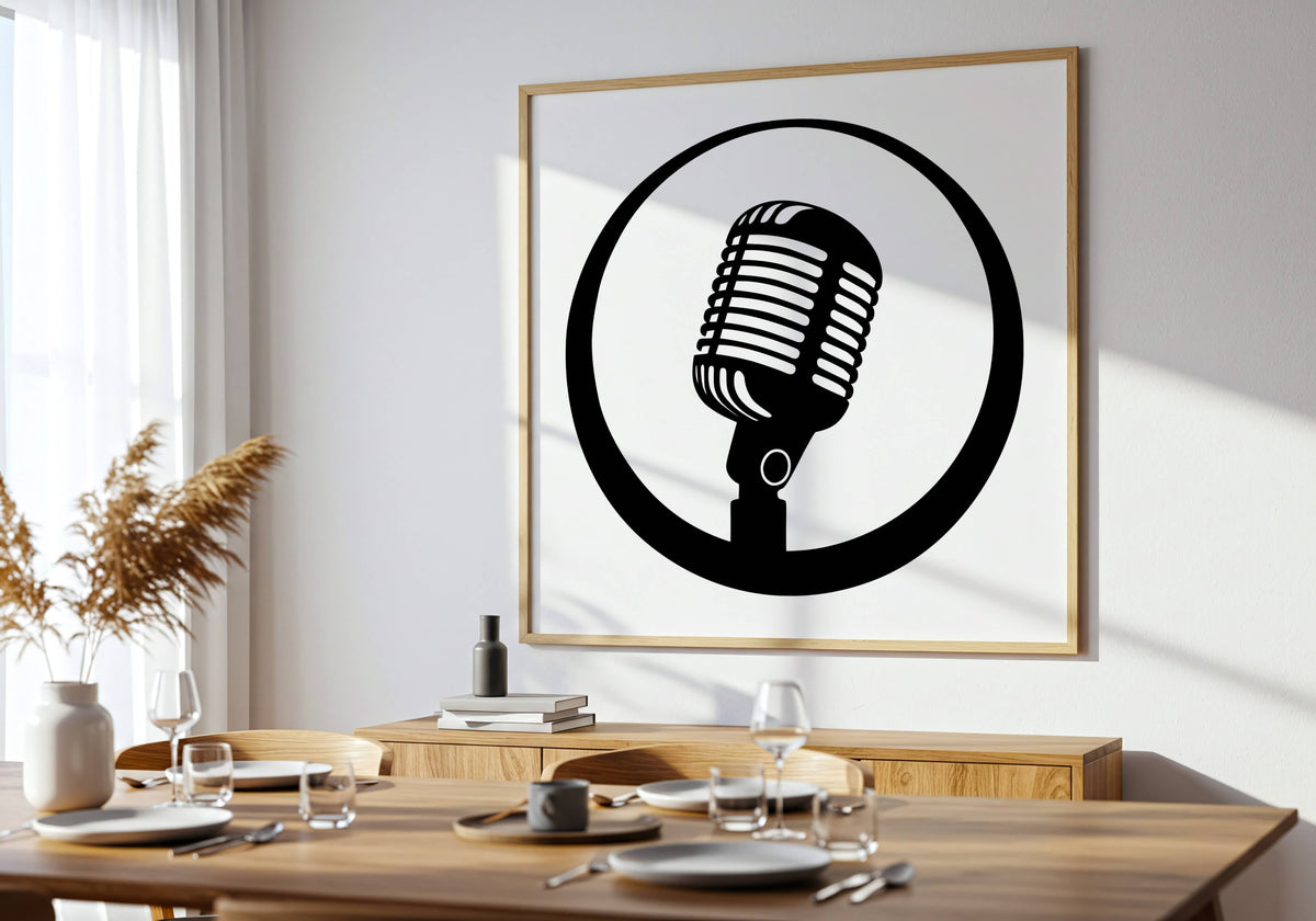 A framed black and white graphic print of a retro microphone hanging on a white wall above a wooden dining table set with plates and glasses.